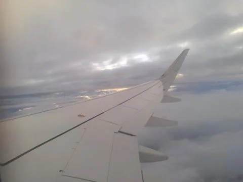 The wing of an airplane with a cloudy background Stock Photos