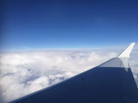 The wing of an airplane with a cloudy background Stock Photos