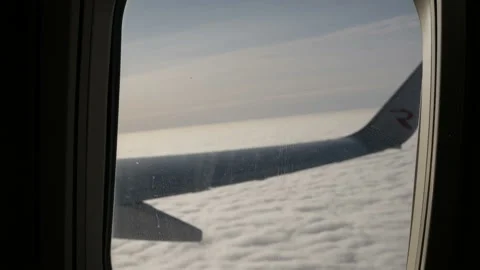 Wing of an airplane flying above the cloud. View from the window of the plane. Stock Footage 120563238