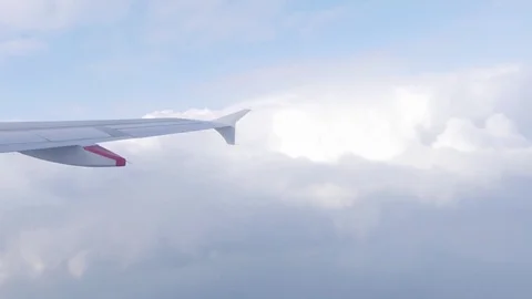 Wing of airplane flying above the clouds on a sunny day 4k Stock Footage 75184922