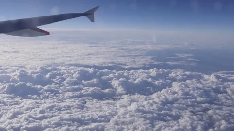Wing of airplane flying above the clouds on a sunny day 4k Video stock 75187429