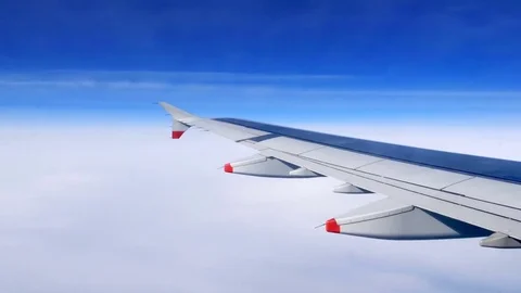 Wing of an airplane flying above the clouds Stock Footage 76087386
