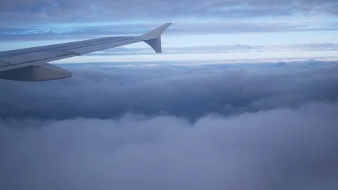 Wing of an airplane flying above the clouds Stock Footage 97364161