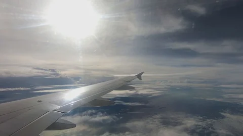 Wing of an airplane flying above the clouds with sunset sky Stock Footage 98172086