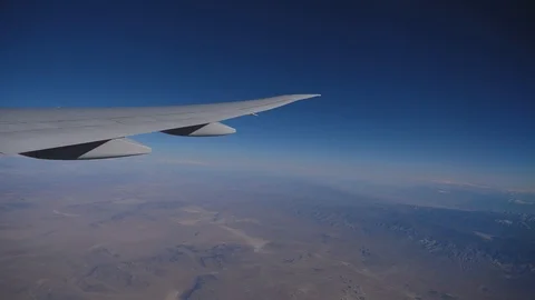 Wing of an airplane flying above the clouds with sunset sky Stock Footage 106614429