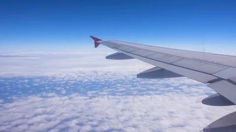 The wing of an airplane flying above the clouds, the view from the window Stock Footage 125241000
