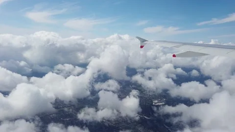 Wing of an airplane flying above clouds and then entering a cloud Video stock 205046264