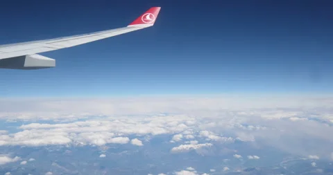 Wing of an airplane flying above the clouds. View from the window of the plane Stock Footage 260570953