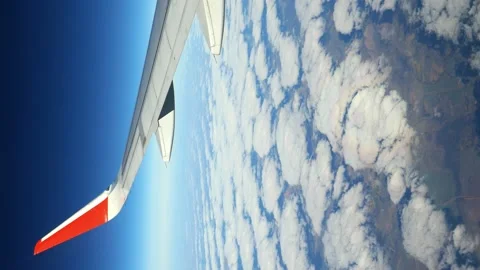The wing of an airplane flying at dawn in the clouds. Video stock 166314735