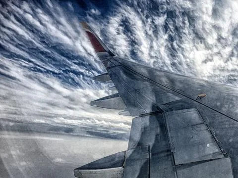 Wing of an airplane flying over the clouds Stock-Fotos