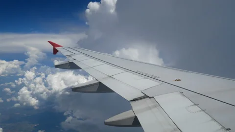 Wing of an airplane flying in to the white clouds and blue sky Stock-Footage 133234047