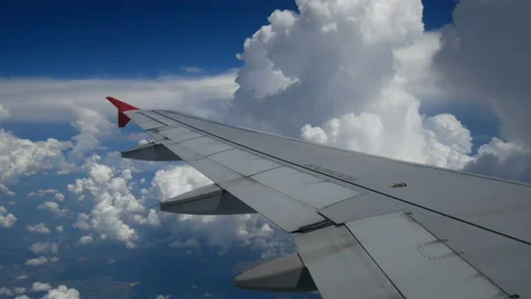 Wing of an airplane flying in to the white clouds and blue sky. Stock Footage 133573526