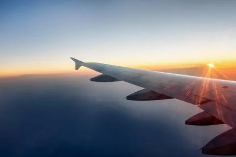 The wing of a airplane at sunset Stock Photos