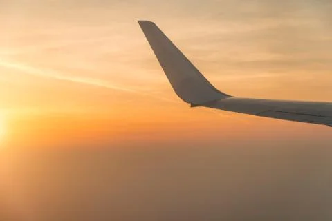 Wing of airplane in the sunset Stock Photos