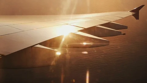 Wing of airplane with sunset sky background. View form the window plane throu Stock Footage 90277735