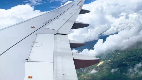 Wing airplane with white clouds and mountain and green nature landscape ground Stock Footage 218340116