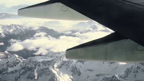 Wing and Engine of a Plane and Snow Covered Alps Mountains Stock-Footage 72182379