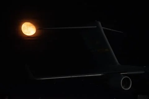 A wing and jet engine from a C-17 at night with a moon in the background Stock Photos