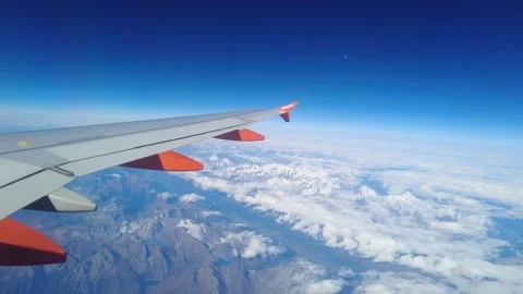 Wing easyjet plane appears air above thick clouds snow capped mountains valleys Vídeo Stock 320845665