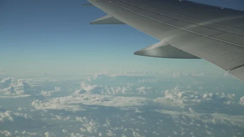 Wing of a flying plane with a blue sky Stock Footage 121753380