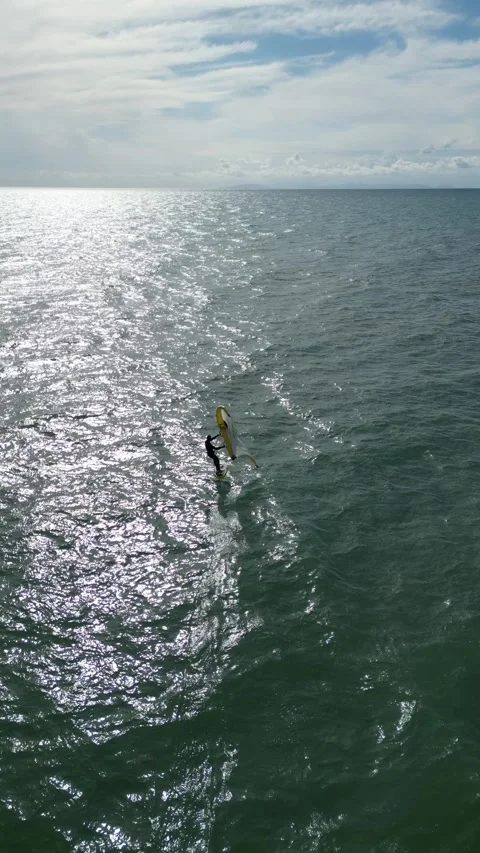 Wing Foiling Athlete Riding on the Sparkling Ocean Surface in Tuscany, Italy Stock Footage 335818848