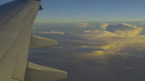 Wing of plane with amber clouds below Stock Footage 346878330