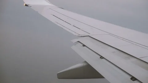 Wing of a Plane and Stormy Clouds Seen Through a Window While Flying Stock Footage 72118739