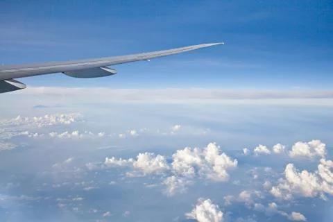 Wing of the plane on blue sky background. Aerial view of Blue sky and Cloud Top Stock Photos