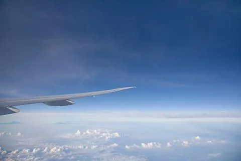 Wing of the plane on blue sky background. Aerial view of Blue sky and Cloud Top Stock Photos