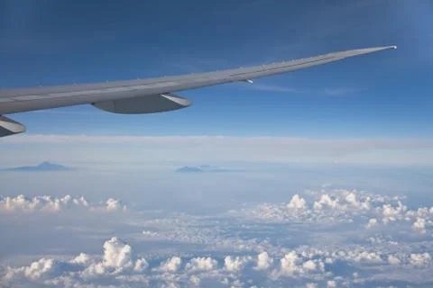 Wing of the plane on blue sky background. Aerial view of Blue sky and Cloud Top Stock Photos