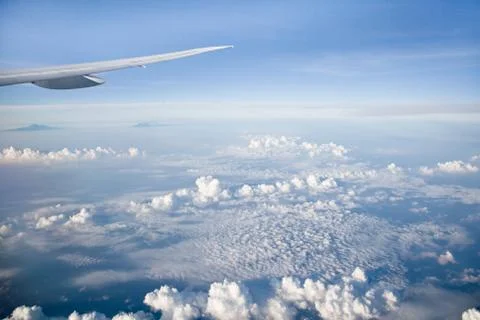 Wing of the plane on blue sky background. Aerial view of Blue sky and Cloud Top Stock Photos