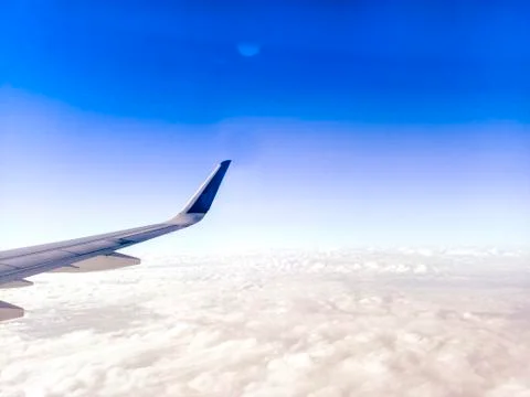 Wing of the plane on blue sky background .  Airplane Wing in Flight from wind Stock Photos