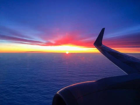 Wing of a plane in clouds at sunset. Foto stock