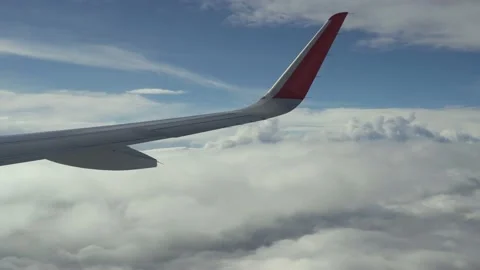 Wing of plane flies above clouds. View from eluminator. Clouds fly by below Stock Footage 162924168
