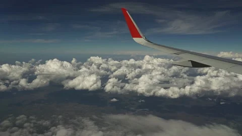 Wing of plane flies above clouds. View from eluminator. Clouds fly by below Stock Footage 166002594