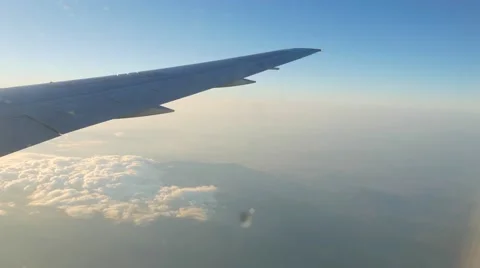 Wing of plane flying over mountains and clouds Stock Footage 62594739