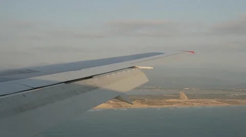 Wing of plane flying over tropical island in sea Stock Footage 62595863