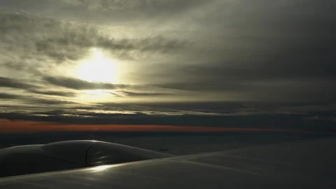 Wing of a plane midair at sunset or sunrise, heavy clouds Stock Footage 178559534