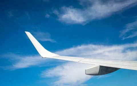 Wing of plane over white clouds. Airplane flying on blue sky. Scenic view fro Stock-Fotos
