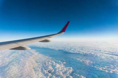 Wing of the plane on sky background. plane wing with cloud patterns. view fro Stockfoto's