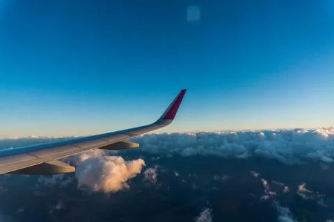 Wing of the plane on sky background. plane wing with cloud patterns. view fro Stockfoto's