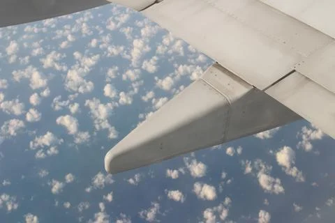 Wing of the plane on sky background - plane wing with cloud patterns Stock Photos