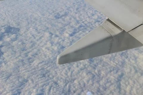 Wing of the plane on sky background - plane wing with cloud patterns Fotos Stock