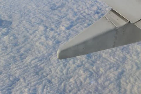 Wing of the plane on sky background - plane wing with cloud patterns Fotos Stock