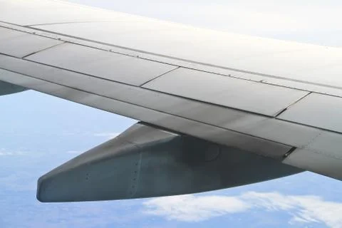 Wing of the plane on sky background - view from the window of a plane Stock Photos