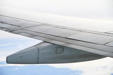 Wing of the plane on sky background - view from the window of a plane Stock Photos