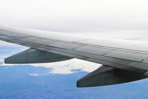 Wing of the plane on sky background - view from the window of a plane Stock Photos