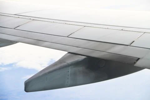 Wing of the plane on sky background - view from the window of a plane Stock Photos