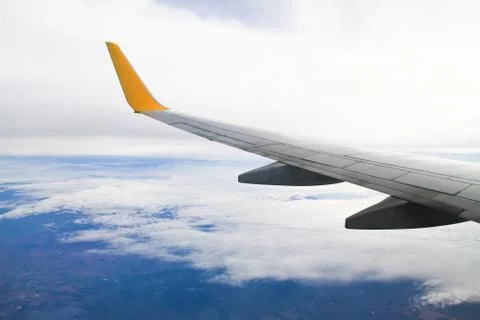 Wing of the plane on sky background - view from the window of a plane Stock Photos