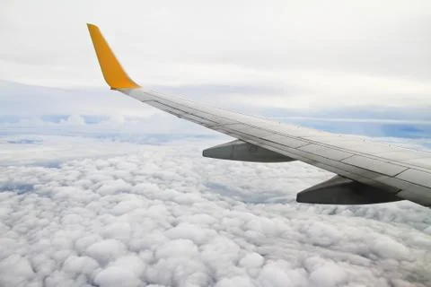 Wing of the plane on sky background - view from the window of a plane Stock Photos